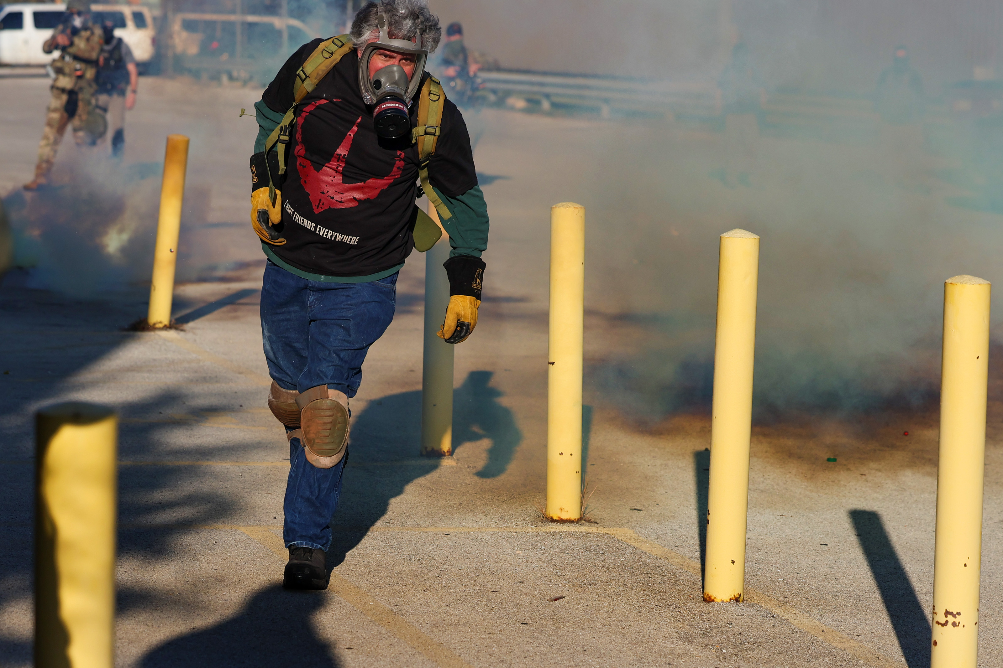 A protester runs away from federal agents firing chemical gas...