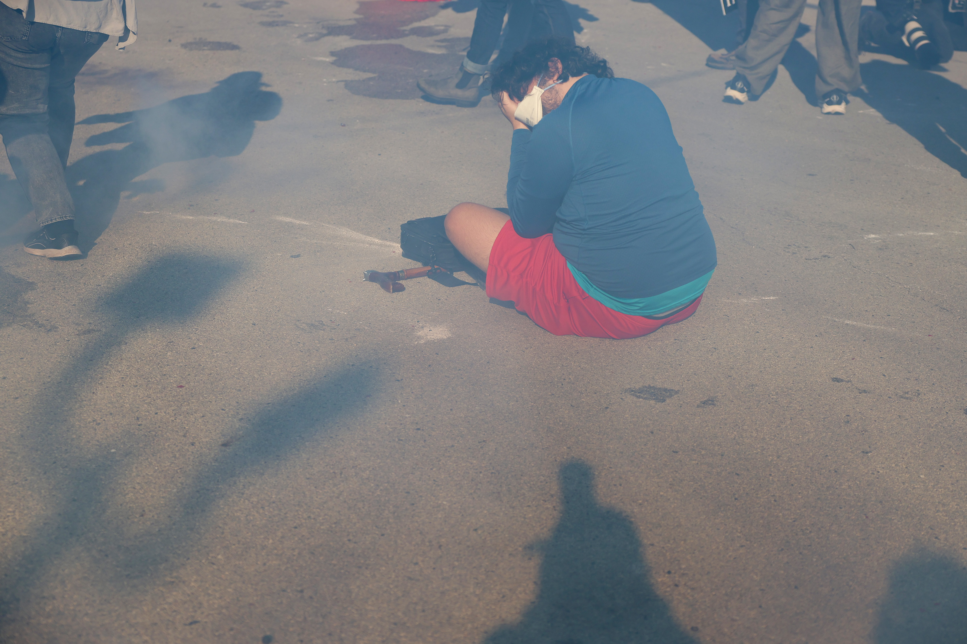 A protester covers his face as chemical gas surrounds him...