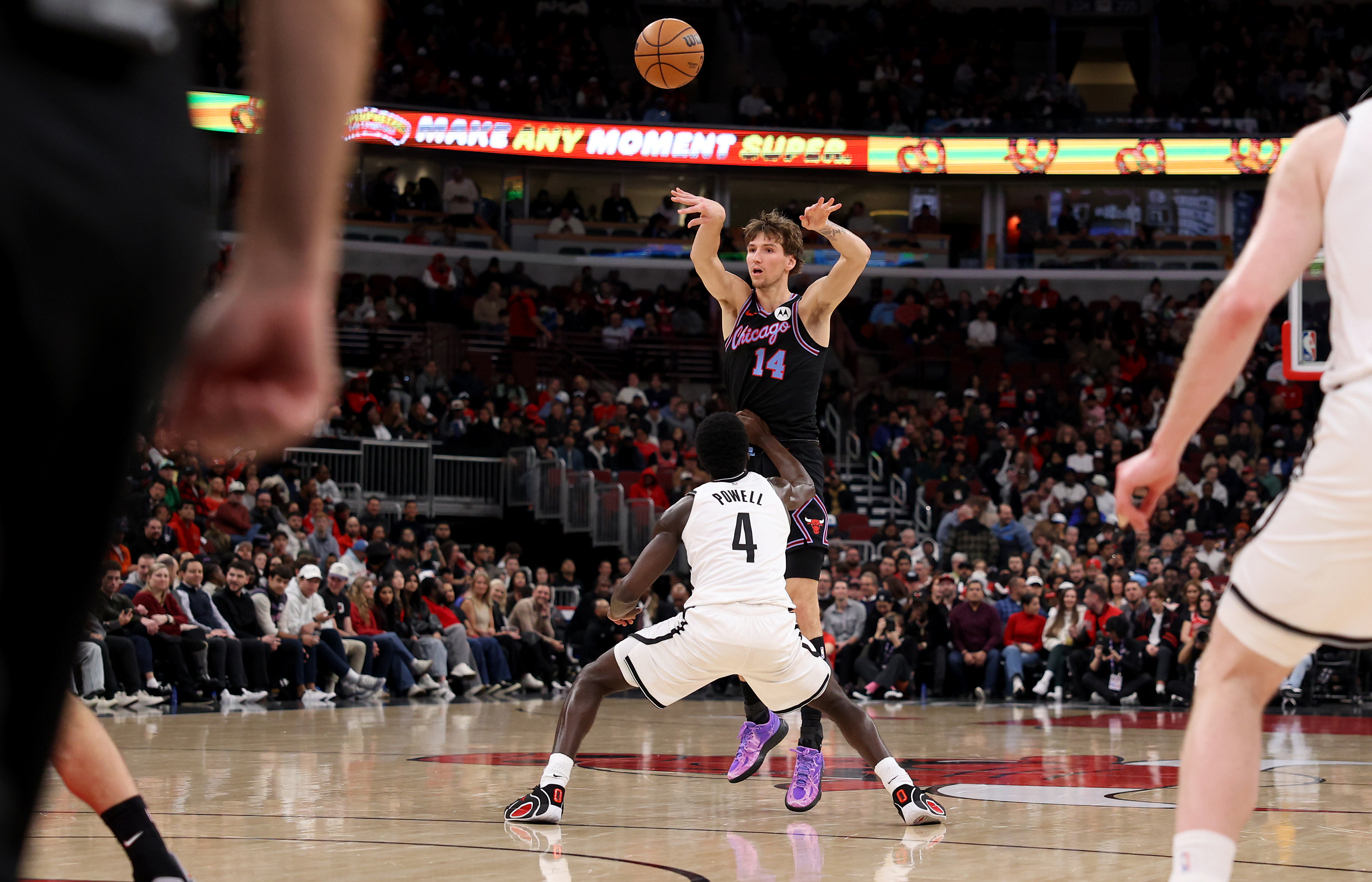 Chicago Bulls forward Matas Buzelis (14) passes the ball over Brooklyn Nets guard/forward Drake Powell (4) in the first half of a game at the United Center in Chicago on Dec. 3, 2025. (Chris Sweda/Chicago Tribune)