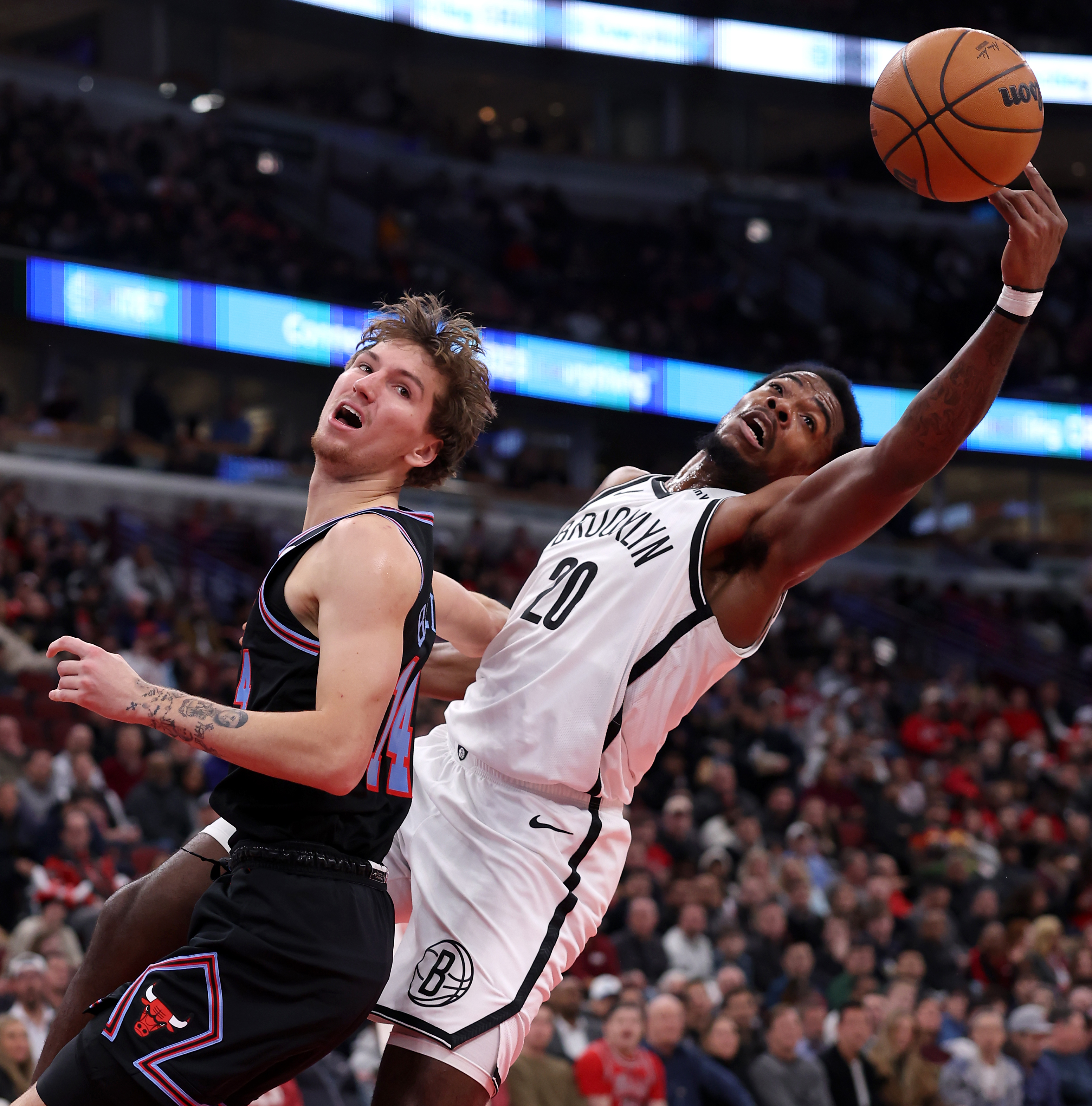 Brooklyn Nets center Day'Ron Sharpe (20) collects the ball after blocking the shot of Chicago Bulls forward Matas Buzelis (left) in the first half of a game at the United Center in Chicago on Dec. 3, 2025. (Chris Sweda/Chicago Tribune)