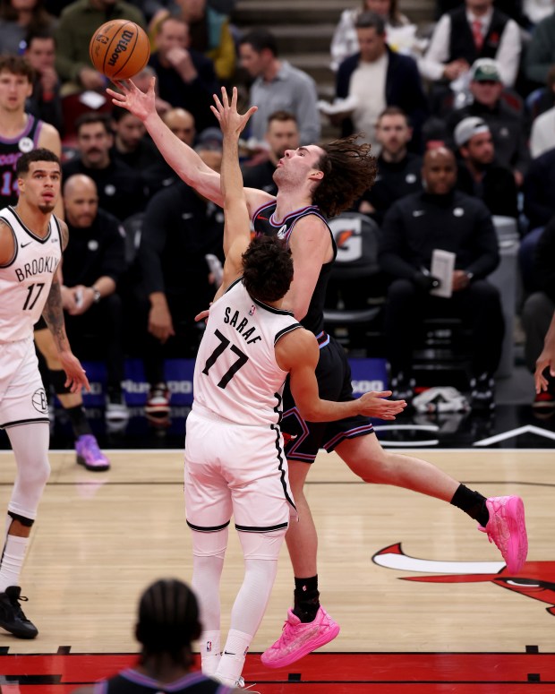 Chicago Bulls guard Josh Giddey (3) puts up a layup against Brooklyn Nets guard Ben Saraf (77) in the second half of a game at the United Center in Chicago on Dec. 3, 2025. (Chris Sweda/Chicago Tribune)