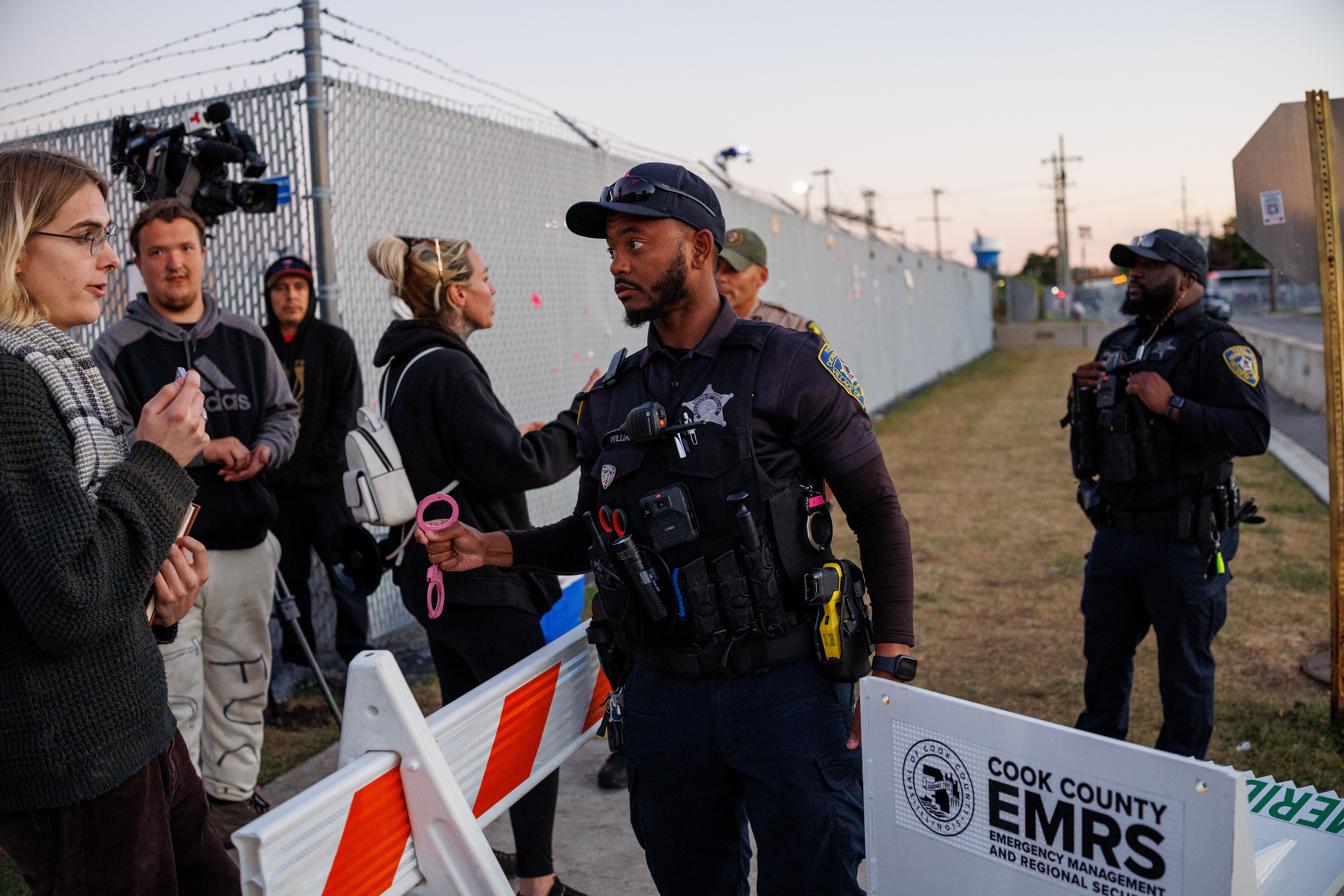 A Broadview police officer moves protesters away from the U.S....