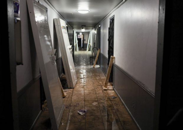 DAWGS Vacant Property Security doors lean against the hallway wall in standing water on the first floor of the 7500 S. South Shore Dr. apartment building in Chicago on Dec. 2, 2025. (Eileen T. Meslar/Chicago Tribune)