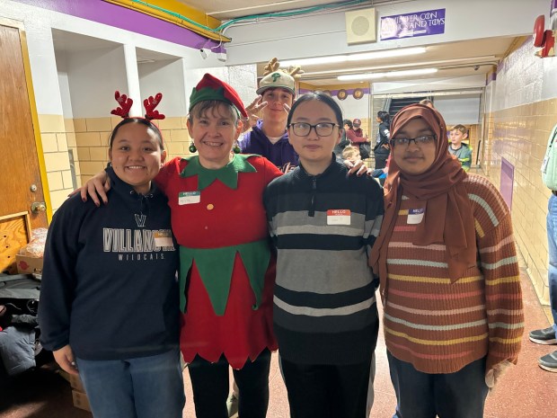 Helping out at the Upper Darby Winter-Fest and Winter-Con are from left, Upper Darby band alto saxphonist Jinuhangma Rai; band parent/elf Kate Long; band drummer Garrett Sindlinger; volunteer Julia Truong and volunteer and high school senior Atefa Mahera. (KATHLEEN E. CAREY - DAILY TIMES)