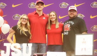 Columbia defensive end Kyten Davis (middle left) stands on stage alongside his family during his signing ceremony to attend Jacksonville State on Friday. (JORDAN KROEGER/Lake City Reporter)