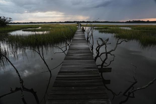 FILE- A storm moves through a salt marsh at sunset Monday, Oct. 6, 2025, in Charleston, S.C. (AP Photo/Joshua A. Bickel, File)