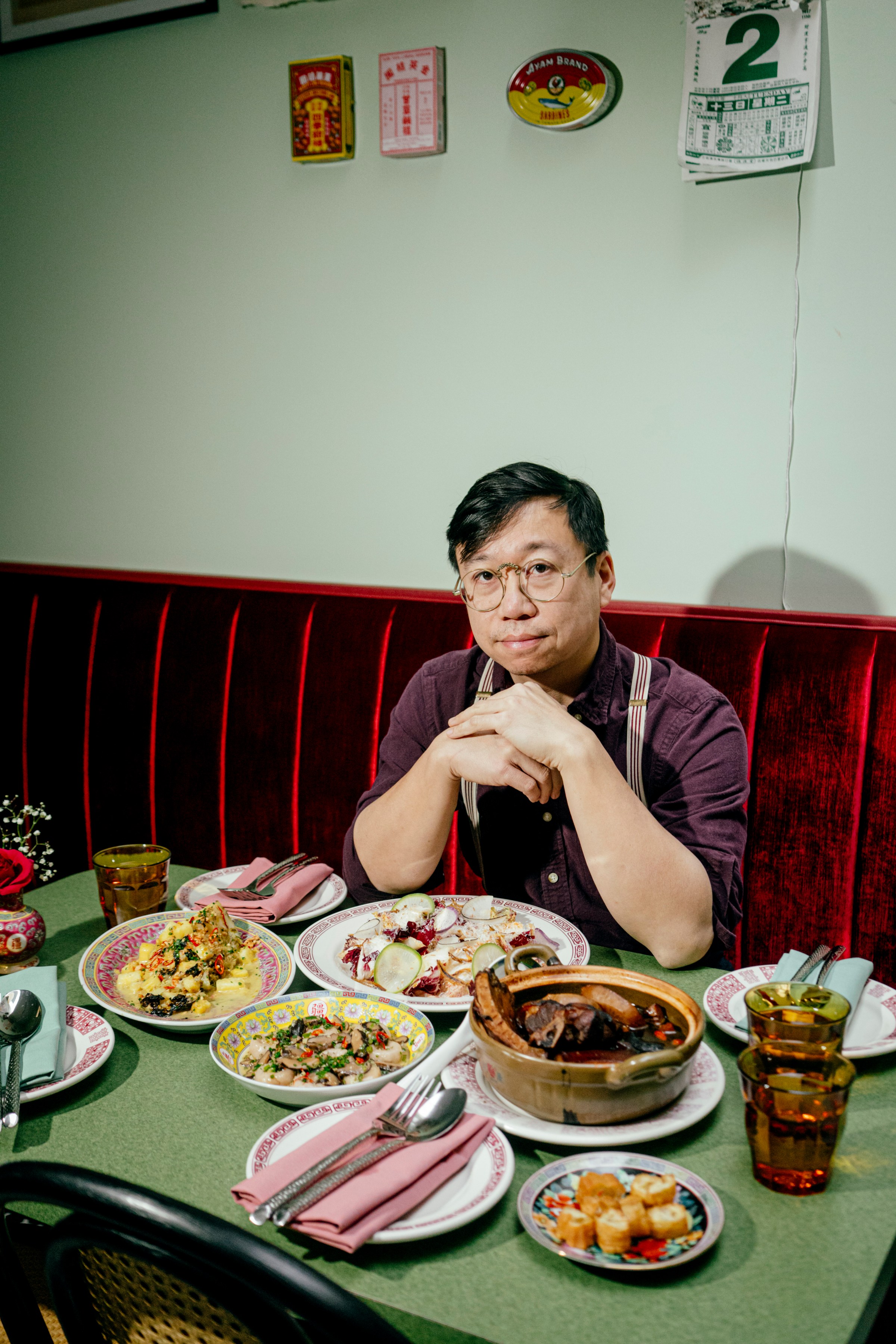 A man in glasses seated at a table with food on it.