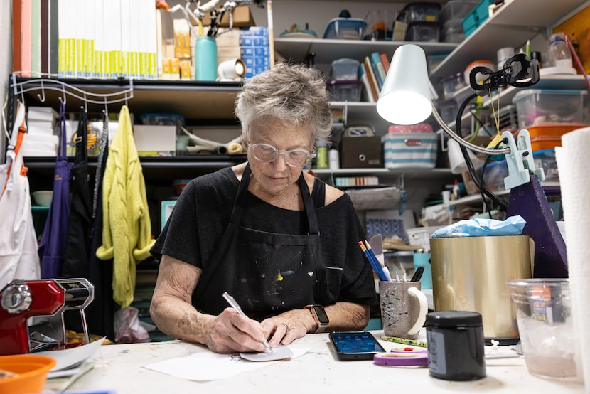 Artist Margo Miller etches into the side of a protein drink container cutout in her...
