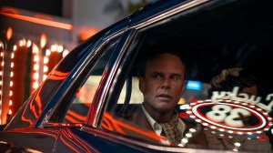 Walton Goggins in 'Fallout' Season 2, in the backseat of a car with the neon lights of Las Vegas on it
