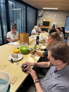 People sit around a table during clay making workshop