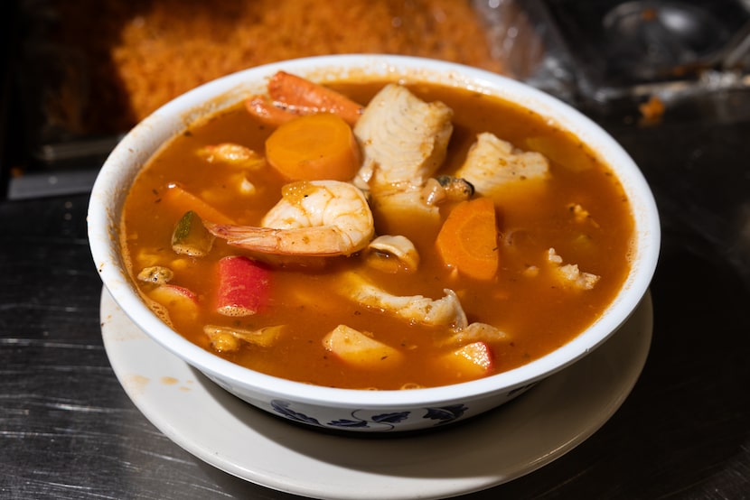 Sopa marinera, soup prepared with a variety of seafood, waits at the pass to be prepared for...