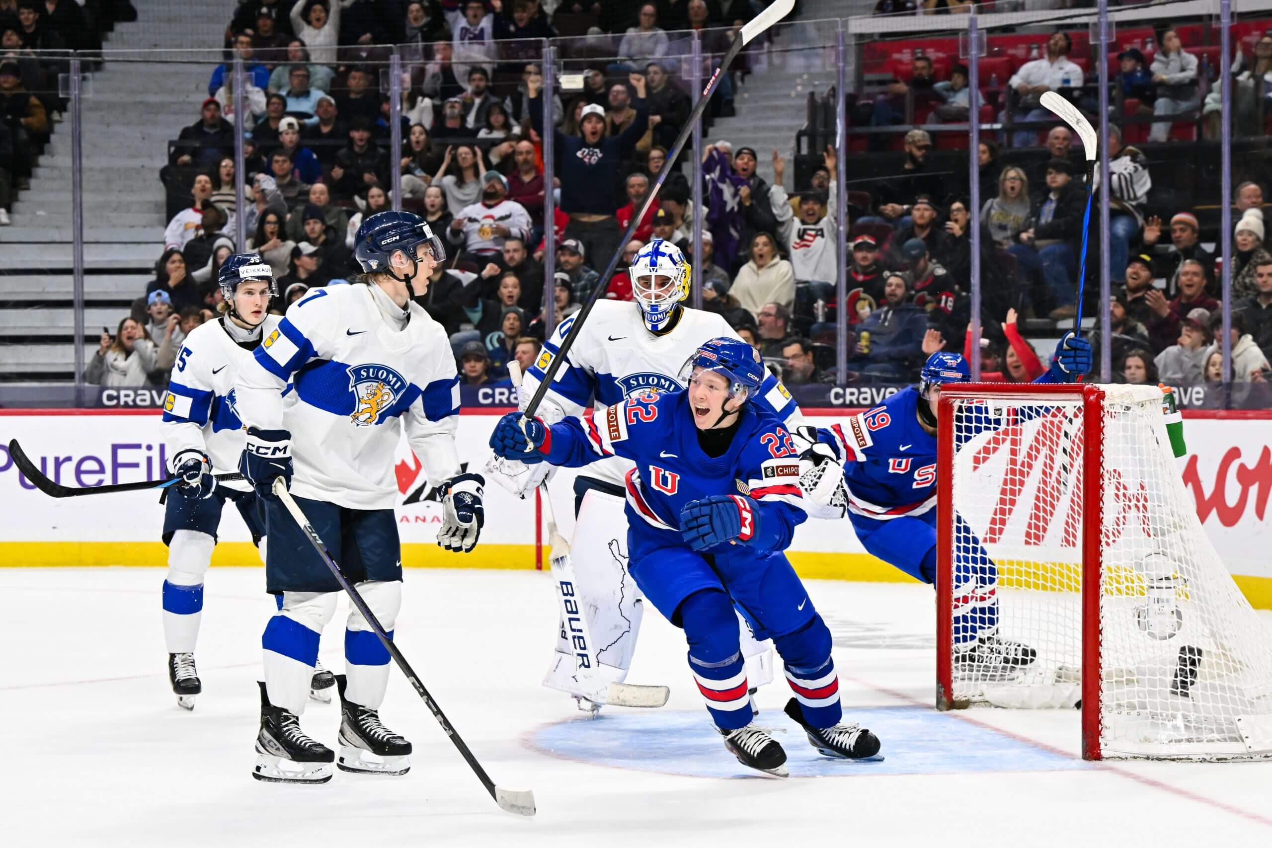 Max Plante and another Team USA teammate cheer with three Team Finland players looking on in dismay in the 2025 World Juniors gold medal game.