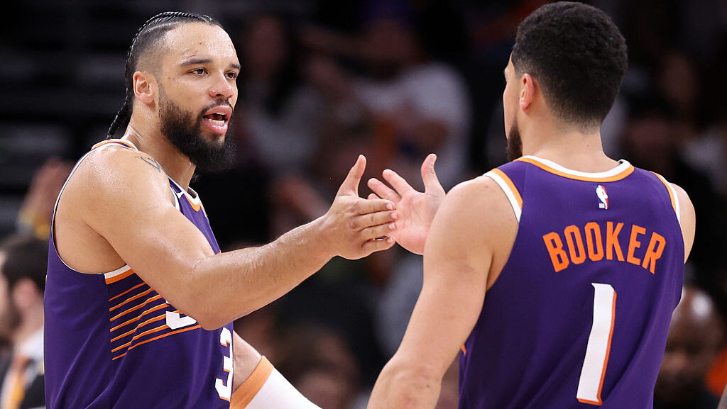 Dillon Brooks #3 of the Phoenix Suns high-fives teammate Devin Booker #1 after Brooks hit a three-p...