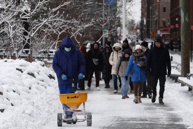 People walk through the snow in Brooklyn after an overnight storm on December 27, 2025 in New York City.  The New York City metro area received over 4 inches of snow, the first time the city had recorded over 4 inches since a winter storm in January 2022. (Photo by Spencer Platt/Getty Images)