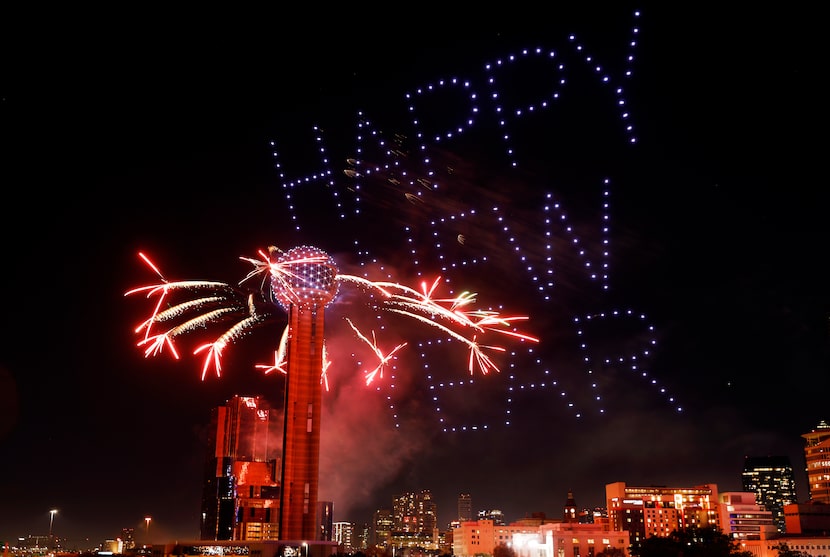 To ring in the new year, fireworks explode off of Reunion Tower as drones create a lighted...
