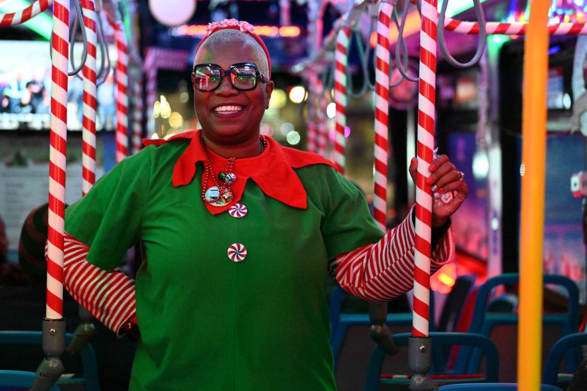 A woman dressed in an elf costume poses on a bus.