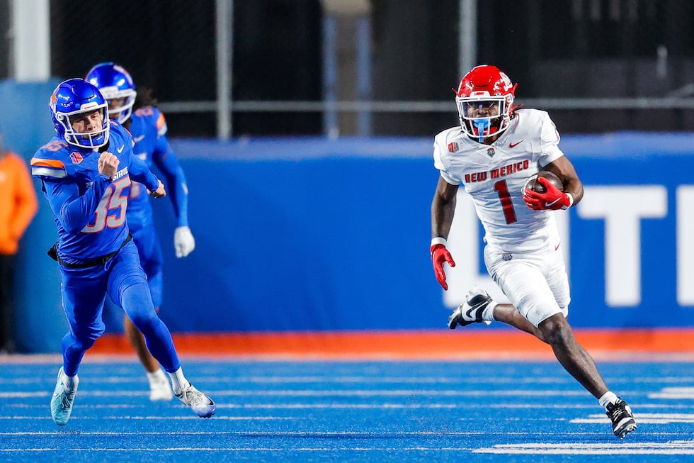 New Mexico running back Damon Bankston (1) runs with the ball in front of Boise State kicker...