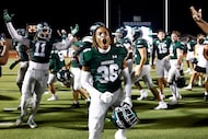 Waxahachie players celebrate on the field after winning a District 11-6A high school...