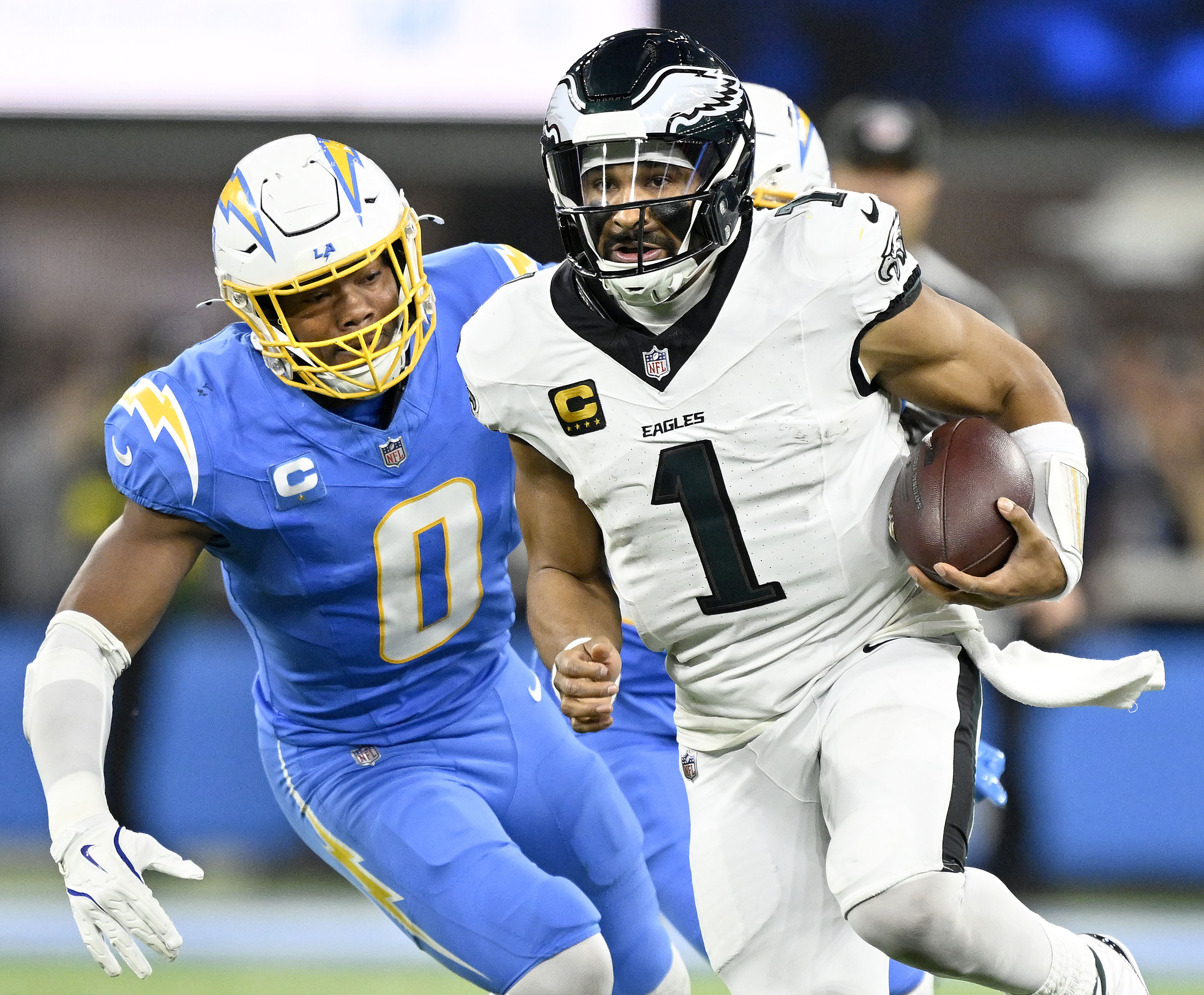 Chargers linebacker Daiyan Henley, left, chases after Philadelphia Eagles quarterback...