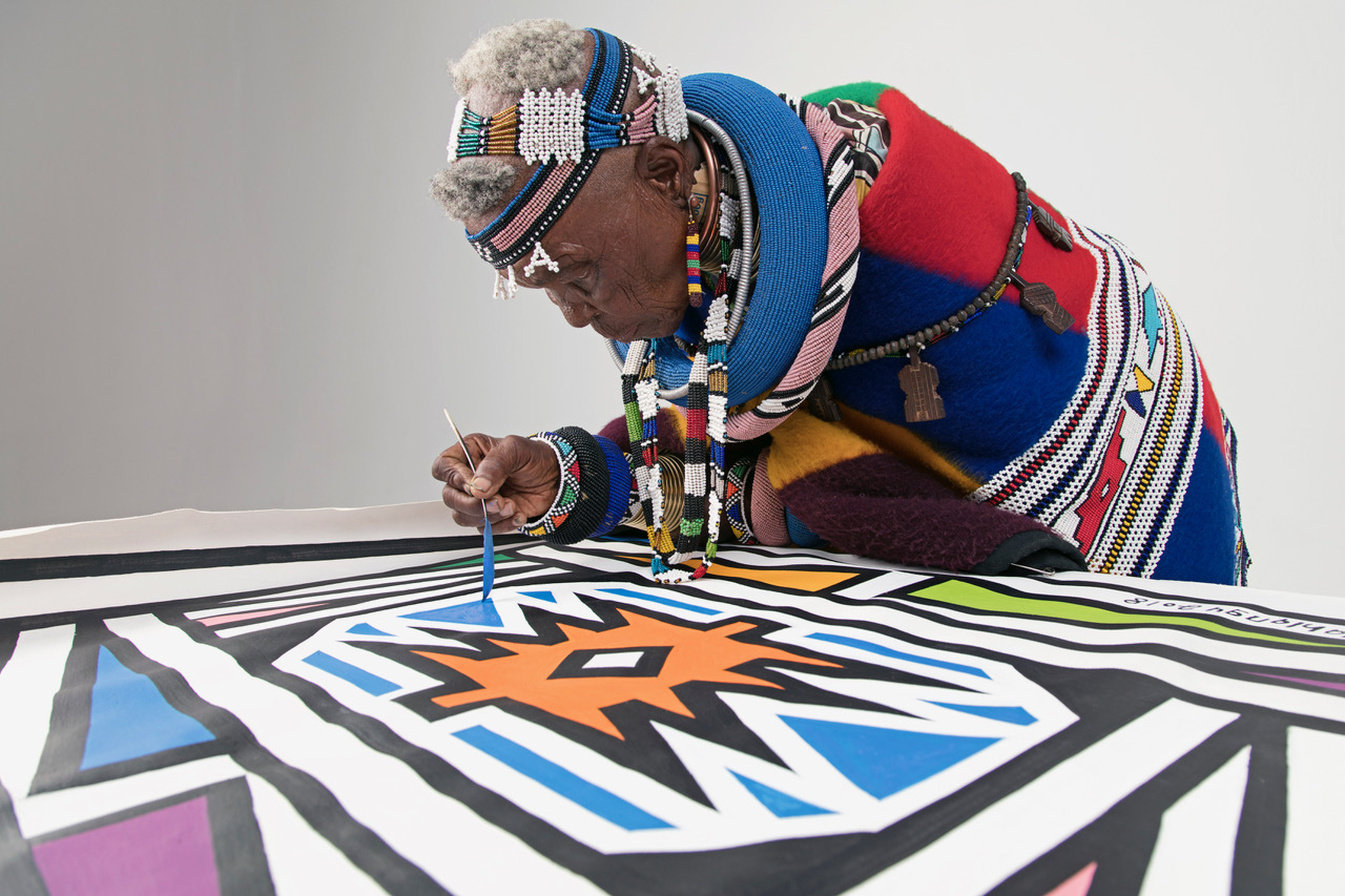 Dr. Esther Mahlangu is pictured painting one of her artworks....