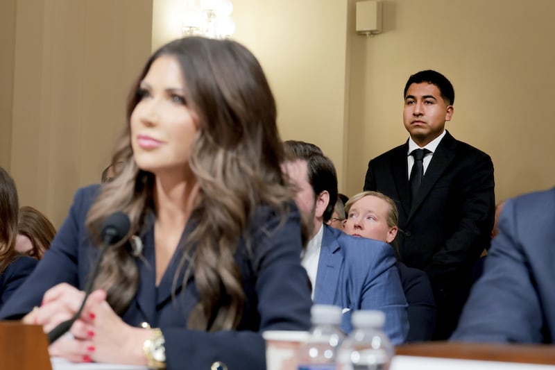 Alejandro Barranco, a U.S. Marine Corps veteran and the son of Narciso Barranco, whose detainment by ICE agents was filmed and shared widely in June, is asked to stand as U.S. Secretary of Homeland Security Kristi Noem testifies at the House Committee on Homeland Security in the Cannon House Office Building on December 11, 2025.