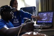 Angel Fischer, a Dallas College student, explains ultrasound views to high school junior...