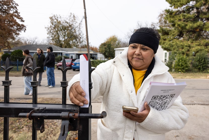 Lucero Ortega, a canvasser for Groundwork Outreach, places a flyer on a gate while...