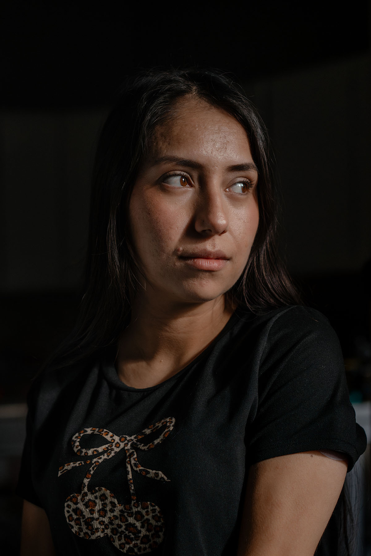 A close-up portrait of Nayra Guzmán looking to the side indoors.