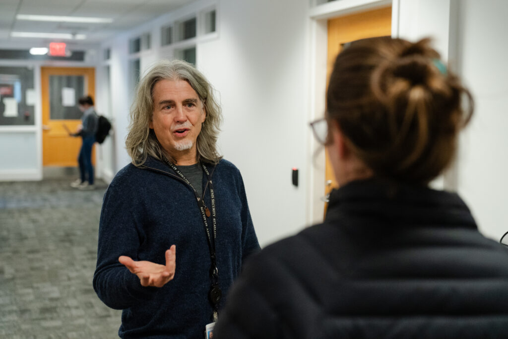 John Quackenbush talks to a colleague at the Harvard T.H. Chan School of Public Health in Boston, Mass. on Nov. 6, 2025.