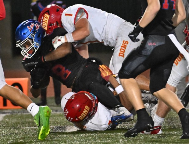 Los Alamitos Kamden Tillis (8) holds onto the ball on the 10-yard line as Cathedral Catholic's Jordyn Fitzpatrick (3) and Cade Smith (1) moves in to stop him during the first half of the CIF Southern California Division 1-AA Regional final, December 5, 2025, at Veterans Stadium in Long Beach.(Photo by Steven Georges, Contributing Photographer)