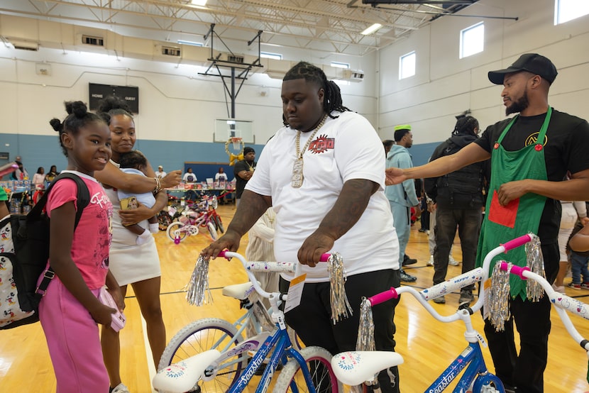 HeadHuncho Amir brings a bike to Emmory, 10, during a holiday drive organized by 'New...