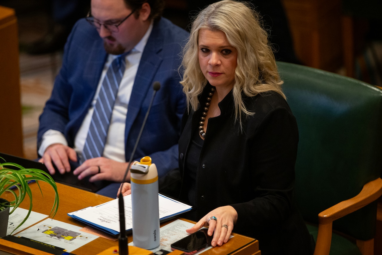 A lawmaker at their desk in the Oregon House chamber of the state capitol building
