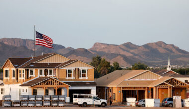 An American flag flies near new home construction at a housing development in Queen Creek.