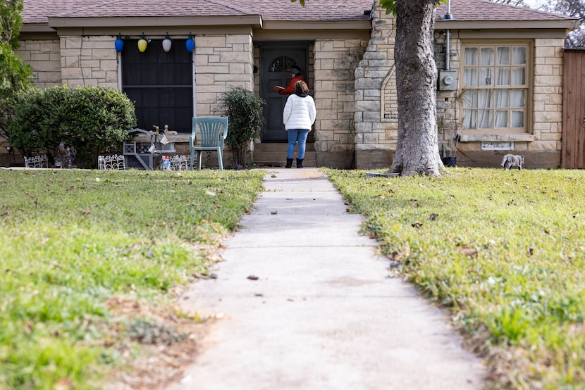 Candelaria Camargo, a canvasser for Groundwork Outreach, knocks on a door while Demetria...