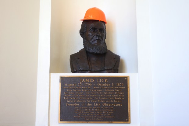 A safety hard hat placed on a bust of James Lick inside the Lick Observatory on Monday, Dec. 29, 2025, in San Jose, Calif. A large metal shutter was torn off the dome of the facility during a recent wind storm. (Aric Crabb/Bay Area News Group)