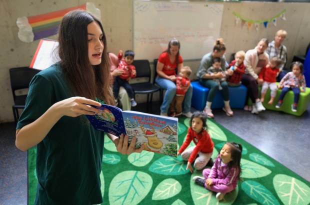 Raquel Rosenthal of the Trinity Theatre Company reads "The Littlest Reindeer" to children at the Children's Library at the San Diego Central Library on Saturday, Dec. 20, 2025. (Hayne Palmour IV / For The San Diego Union-Tribune)