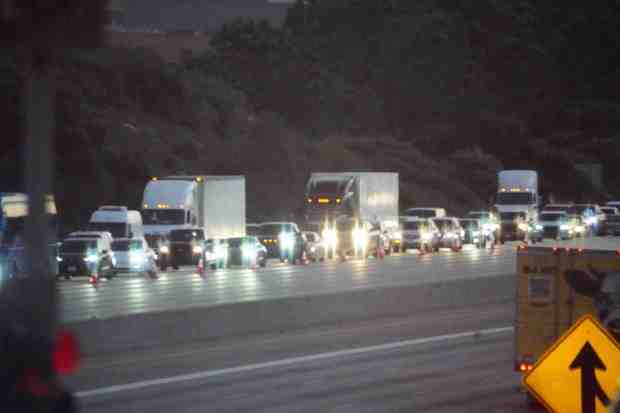 Traffic is heavily delayed on Interstate 5 Friday due to a police incident on the Del Mar Heights Road overpass. (Michael Ho / For The San Diego Union-Tribune)