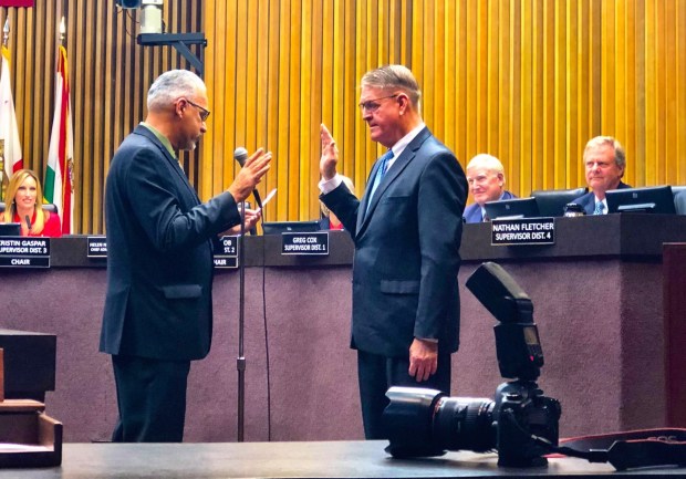 Newly re-elected San Diego County Treasurer-Tax Collector Dan McAllister is sworn in by Michael Brunker, the longtime CEO of the Jackie Robinson Family YMCA, on Jan. 7, 2019. (Michael Brunker)