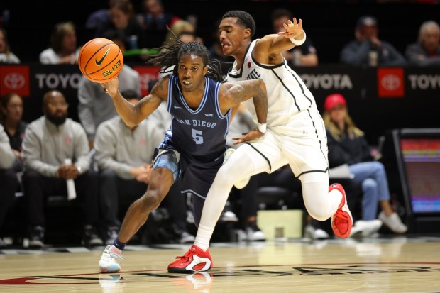 Ty-Laur Johnson #5 of USD drives to the basket against Sean Newman Jr. #4 of San Diego State at Viejas Arena on Wednesday, Oct. 29, 2025 in San Diego, California. (Meg McLaughlin / The San Diego Union-Tribune)
