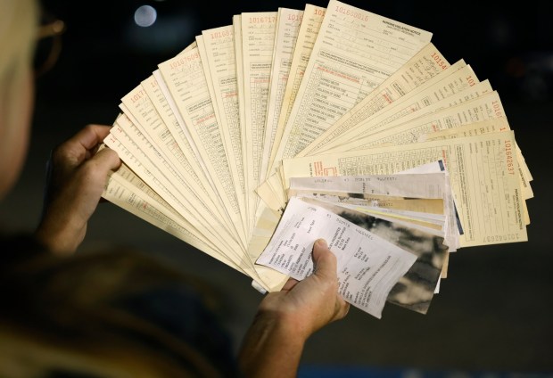 Miranda Snyder, who lives in an RV, holds some of the tickets she has gotten from parking overnight on a city street. (K.C. Alfred / The San Diego Union-Tribune)