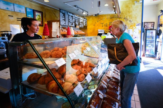 Jennifer Sutherland assists Holly Bertz with selecting a pastry at the bakeshop of The French Gourmet on Friday, Dec. 5, 2025, in San Diego, CA.  (Nelvin C. Cepeda / The San Diego Union-Tribune)
