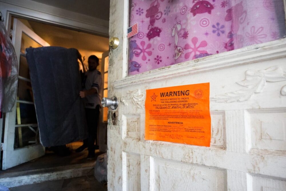 A man removes items from a home in Southwest Austin in 2018. Several residents of the home were forced to leave after a judge ruled against them in eviction court.