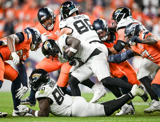 Travis Etienne Jr. (1) of the Jacksonville Jaguars charges ahead against the Denver Broncos during the fourth quarter of the Jaguars' 34-20 win at Empower Field at Mile High in Denver, Colorado on Sunday, Dec. 21, 2025. (Photo by AAron Ontiveroz/The Denver Post)