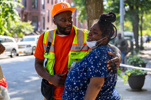 Starkeisha Payne, right, being comforted by her brother, was at home on the third floor at 920 Lafayette when a third alarm fire broke out at 922 Lafayette Ave that was reportedly started by squatters, in Brooklyn, Wednesday, June 4, 2025. (Shawn Inglima/ New York Daily News)