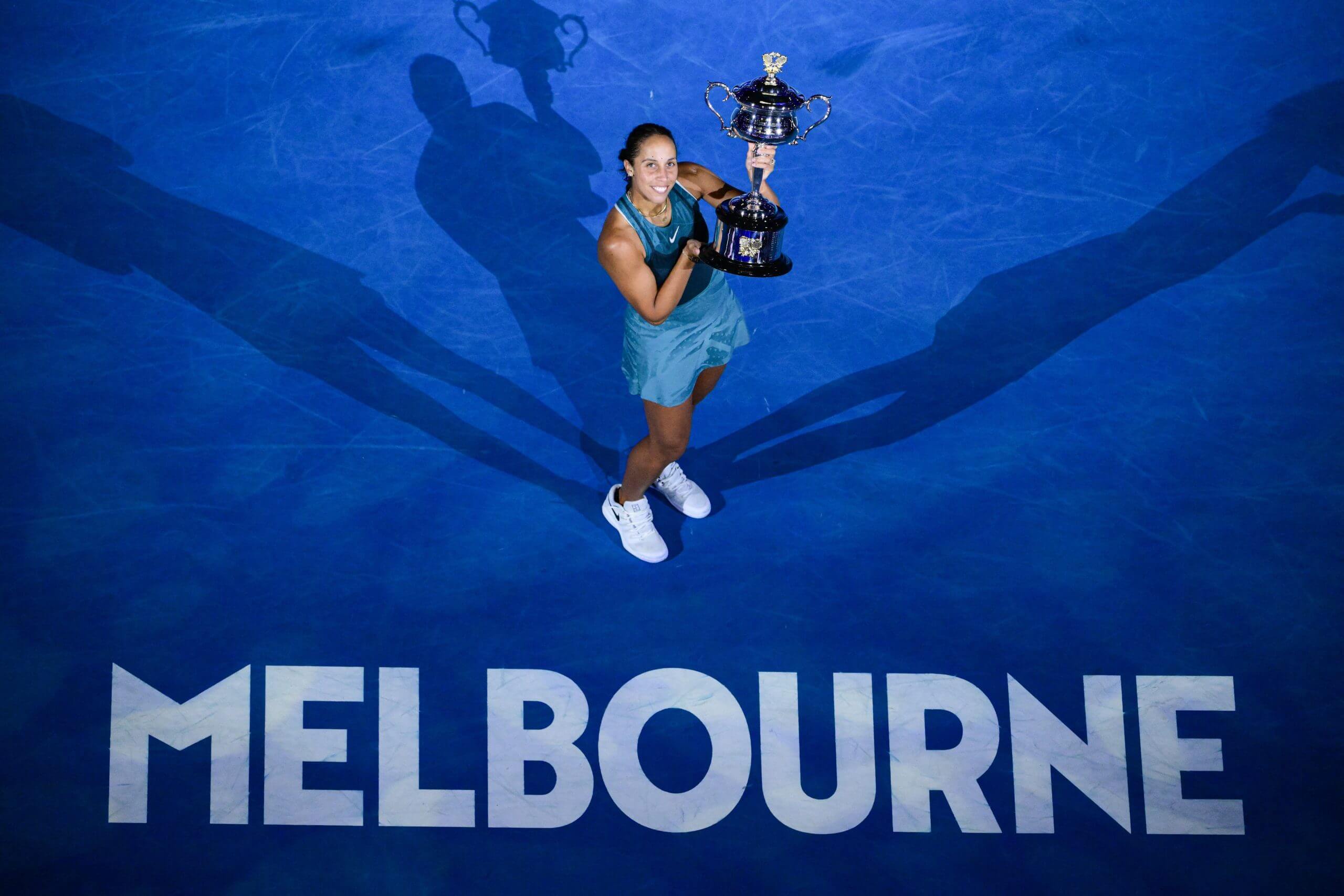 Madison Keys holds the Australian Open trophy in a birdseye shot in which she stands above the word "Melbourne" in capital letters.
