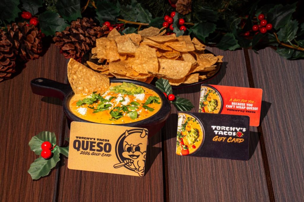 Chips, queso and gift cards on a table.