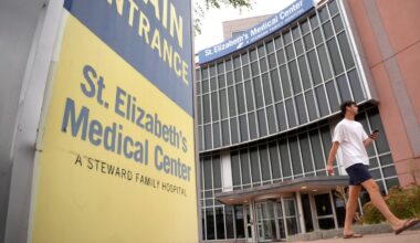 A passer-by walks past an entrance to St. Elizabeth's Medical Center, now called BMC Brighton, on Thursday, Sept. 19, 2024, in the Brighton neighborhood of Boston.  (AP Photo/Steven Senne)
