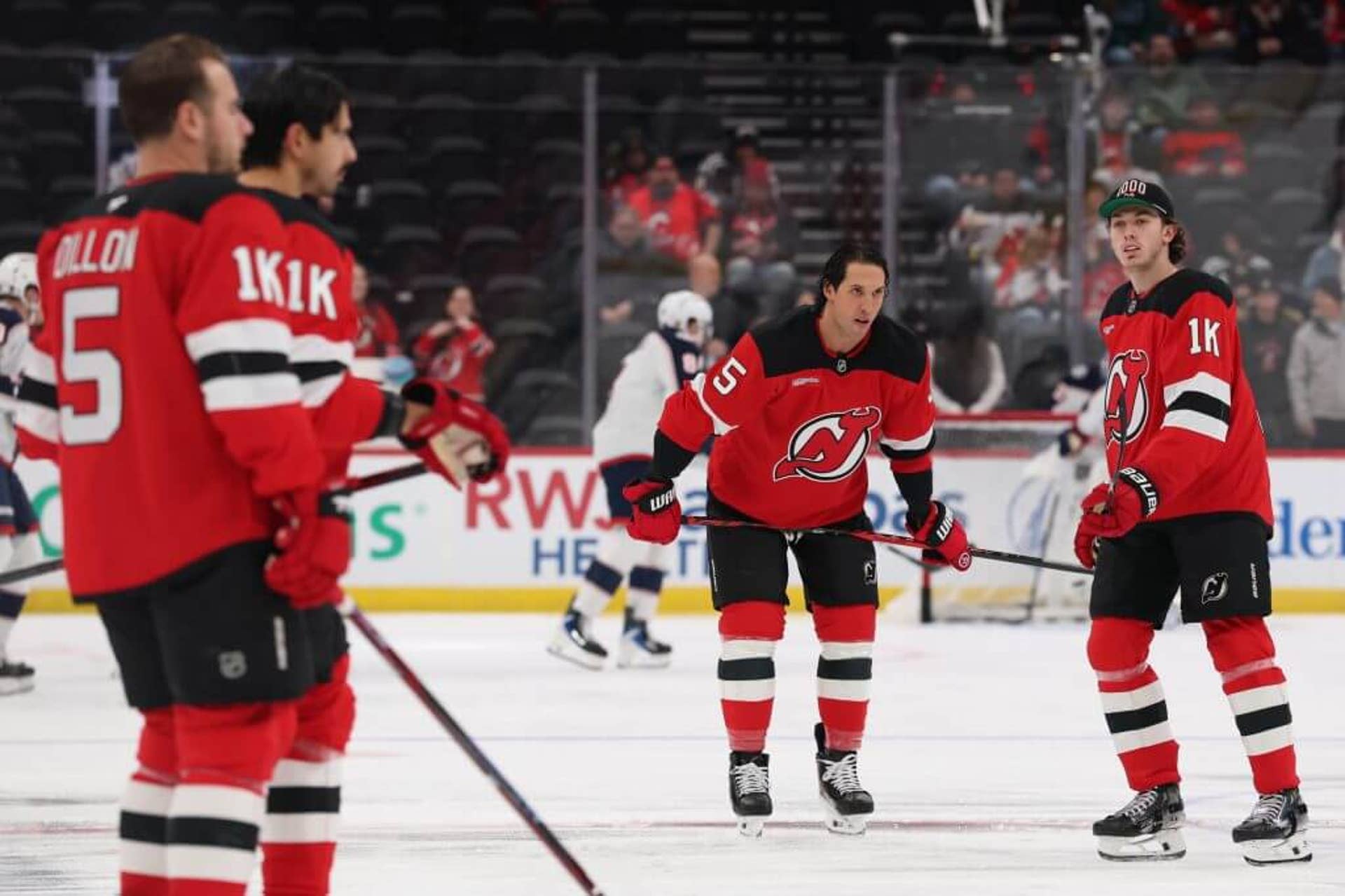 New Jersey Devils players warm up before a game against the Columbus Blue Jackets without helmets and wearing jerseys with No. 5 on the back and '1K' on the sleeve to honor Brendan Dillon's 1,000th game.