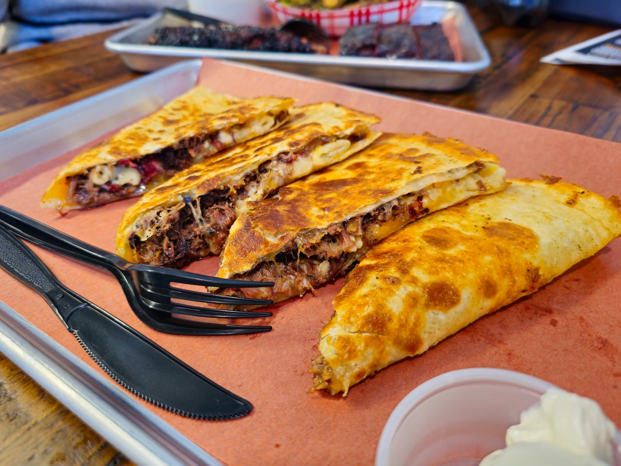 A quesadilla filled with mac and cheese and shredded beef brisket.