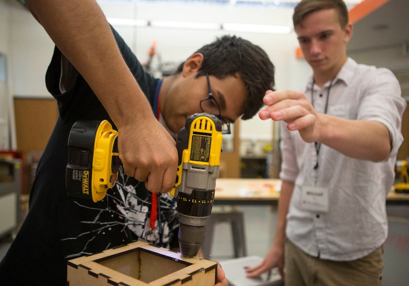 Elias Galarza, 17, of Dallas drills a hole for a hinge under the guidance of instructor...